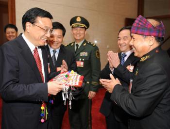 A deputy to the Second Session of the 11th National People's Congress (NPC) from southwest China's Yunnan Province presents an ornament to Li Keqiang (front, L), member of the Standing Committee of the Political Bureau of the Communist Party of China (CPC) Central Committee, in Beijing, capital of China, March 10, 2009. Li Keqiang joined a panel discussion with deputies to the Second Session of the 11th NPC from southwest China's Yunnan Province on Tuesday. (Xinhua/Yang Zongyou)