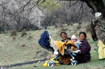 Villagers of the Tibetan ethnic group enjoy the flowers at the bank of the Nyang River in Nyingchi of southwest China's Tibet Autonomous Region, March 8, 2009. Peach trees have blossomed to welcome the spring season in the area. (Xinhua/Ye Hui) 