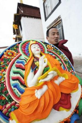 A Lama carries a ghee figure of Buddha in the Chanbaling Temple in Qamdo, southwest China's Tibet Autonomous Region, Mar. 11, 2009. An annual celebration for the ghee flowers and lanterns festival was held in the Chanbaling Temple on Wednesday, to pray for peace and happiness in the new year. (Xinhua/Pubu Zhaxi)