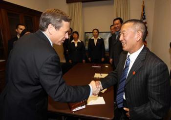 Shingtsa Tenzinchodrak (R Front), a living Buddha of the Kagyu sect of the Tibetan Buddhism and vice chairman of the Standing Committee of the People's Congress of Tibet Autonomous Region of China, shakes hands with Mark Kirk (L Front), chairman of the U.S.-China Working Group in the House, in Washington, the United States, March 17, 2009. (Xinhua Photo)