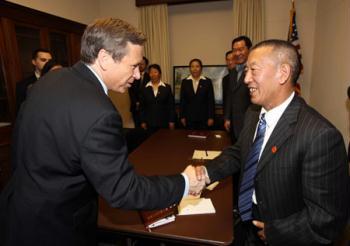 Shingtsa Tenzinchodrak (R Front), a living Buddha of the Kagyu sect of the Tibetan Buddhism and vice chairman of the Standing Committee of the People's Congress of Tibet Autonomous Region of China, shakes hands with Mark Kirk (L Front), chairman of the U.S.-China Working Group in the House, in Washington, the United States, March 17, 2009.  (Xinhua Photo)
