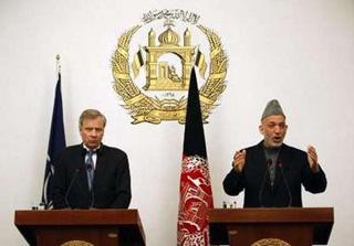NATO Secretary General Jaap de Hoop Scheffer (L) watches as Afghanistan's President Hamid Karzai speaks during a news conference in Kabul March 18, 2009.REUTERS/Ahmad Masood