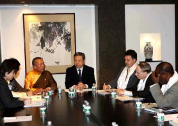 Shingtsa Tenzinchodrak (5th R), a living Buddha of the Kagyu sect of Tibetan Buddhism and vice chairman of the Standing Committee of the People's Congress of Tibet Autonomous Region of China, talks with New York State Assemblyman Felix Ortiz (3rd R) and other assemblymen in New York, the United States, March 19, 2009. (Xinhua Photo)
