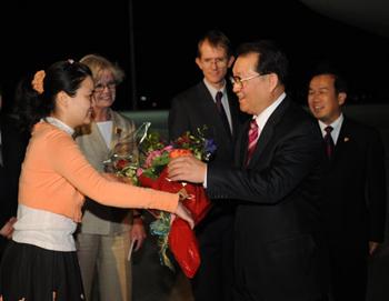 Li Changchun (R Front), member of the Standing Committee of the Political Bureau of the Central Committee of the Communist Party of China, receives a bunch of flowers presented by a girl greeting him upon his arrival at the airport in Canberra, capital of Australia, March 20, 2009. Li Changchun arrived in Canberra on Friday for an official goodwill visit. (Xinua/Liu Jiansheng)