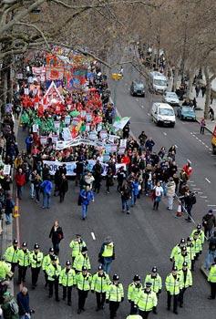 Police officers keep order in front of a procession of demonstrators in London on March 28, 2009. The Put People First group, an alliance of more than 150 unions, on Saturday organized the demonstration, calling on the leaders of the Group of 20 Countries (G20) to adopt sustainable policies that can lead the world out of recession. The demonstrators also urged the leaders to attach importance to global environment protection and to stablize the world political situation. The G20 leaders will meet in London on April 2. (Xinhua/Zeng Yi)