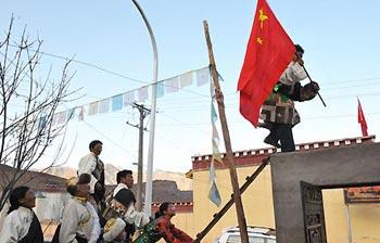 A Tibetan man in traditional dress plugs the national flag on the roof of his house during the celebration of the first Serfs Emancipation Day at home in Qamdo, southwest China's Tibet Autonomous Region, March 28, 2009. (Xinhua/He Junchang)