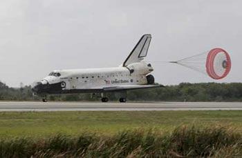 The space shuttle Discovery has its drag parachute deployed as it rolls past the runway convoy after it returned to earth at the Kennedy Space Center in Cape Canaveral, Florida March 28, 2009. The landing ends Mission STS-119 to the International Space Station. (Xinhua/Reuters Photo)