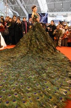 A model presents a wedding dress decorated with peacock feathers at the wedding expo held in Nanjing, capital of east China's Jiangsu Province, March 28, 2009. (Xinhua Photo)