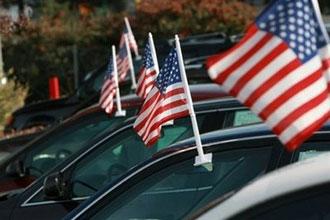 US flags on cars for sale at an auto-dealership in Santa Rosa, California. President Barack Obama is set to unveil a much-anticipated plan on the future of ailing US automakers, his spokesman has said.(AFP/Getty Images/File/Justin Sullivan)