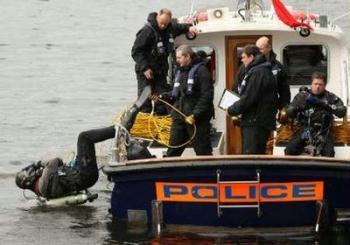 A police diving team make a security search of the Royal Victoria Dock, ahead of next week's G20 summit at the ExCeL centre, London March 26, 2009. REUTERS/Dominic Lipinski/Pool