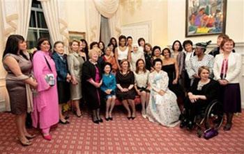 Sarah Brown, wearing a brown dress, seated center with US first lady Michelle Obama, standing behind her, is joined by the wives and guests of G20 delegates attending a dinner at London's Downing Street, Wednesday, April 1, 2009.(AP Photo/Christopher Furlong/pool)