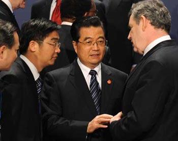 Chinese President Hu Jintao (2nd R) talks with British Prime Minister Gorden Brown (R) as they prepare to pose for a family photo during the Group of 20 summit in London, Britain, April 2, 2009. (Xinhua/Li Xueren)