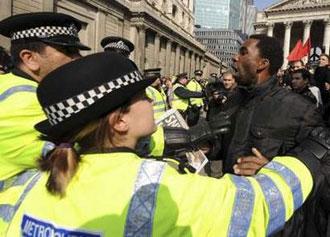Police push a demonstrator during a protest outside the Bank of England in London April 2, 2009.REUTERS/Andrew Parsons