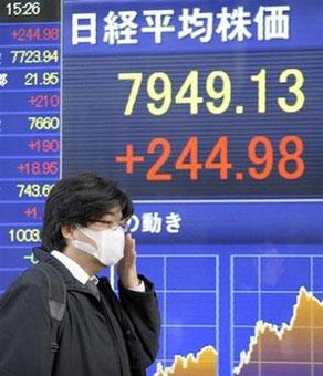 A passer-by walks past a stock indicator of the Tokyo Stock Exchange.(AFP/Toshifumi Kitamura)