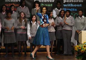 U.S. first lady Michelle Obama waves to students during a visit to Elizabeth Garrett Anderson Language School in London, April 2, 2009.(Xinhua/Reuters Photo)