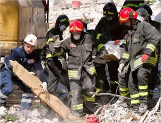 Firefighters carried out a body from the rubble of a collapsed building, in L'Aquila. Entire blocks were flattened in the mountain city and nearby villages. Italy's prime minister, Silvio Berlusconi, said Tuesday that rescue efforts would continue for another 48 hours and that there was still hope of finding people alive under fallen masonry and walls.