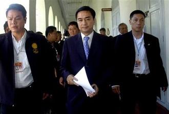 Thailand's Prime Minister Abhisit Vejjajiva, center, arrives for a meeting before declaring a state of emergency at Interior Ministry in Bangkok, Thailand, Sunday, April 12, 2009.(AP Photo)