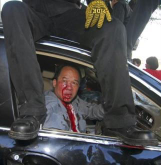 The driver of Thai prime minister's secretary Niphon Prompan is seen injured in his car after he was attacked by supporters of former Prime Minister Thaksin Shinawatra at the Interior Ministry in Bangkok April 12, 2009.[Agencies]