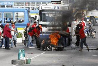 Supporters of ousted Thai prime minister Thaksin Shinawatra burn tyres as they block a main road in Bangkok April 13, 2009.REUTERS/Vivek Prakash