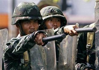 Thai soldiers point to protesters who threw fire bomb to them after the troops cleared an intersection in downtown Bangkok, Thailand, Monday, April 13, 2009.(AP Photo/Vincent Yu)