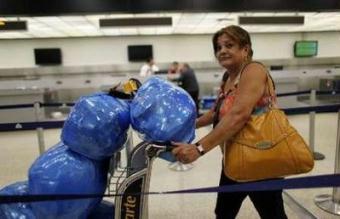 Aracely Blanco, a Cuban-American, leaves the counter of flights to Cuba at the Miami International Airport, Florida April 13, 2009.U.S. President Barack Obama has directed officials to look at the possibility of starting regularly scheduled commercial flights between the United States and Cuba, the White House said on Monday.REUTERS/Carlos Barria