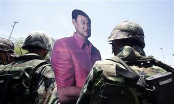 An anti-government protester and supporter of ousted Thai Prime Minister Thaksin Shinawatra holds a cutout of Thaksin as they leave from outside Government House in Bangkok, Thailand, Tuesday, April 14, 2009.(AP Photo/Wason Wanichakorn)