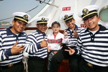 A little boy poses with marines of the sailing ship ARM Cuauhtemoc of the Mexican Navy in Qingdao, east China's Shandong Province, April 22, 2009. Part of foreign naval vessels which came to attend the 60th anniversary celebration of Chinese People's Liberation Army Navy was open to public on Wednesday, attracting lots of visitors. (Xinhua/Zha Chunming)