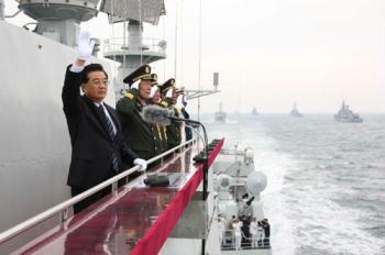 Chinese President Hu Jintao (L) waves to the navy vessels which are being reviewed while aboard the destroyer Shijiazhuang in waters off Qingdao, east China's Shandong Province, April 23, 2009. A parade displayed 25 naval vessels and 31 aircrafts of the PLA Navy, including two nuclear submarines, as part of a celebration to mark the 60th anniversary of the founding of the PLA Navy.(Xinhua/Wang Jianmin)