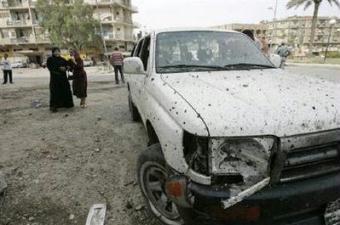 A resident cries near a damaged vehicle at the site of a suicide bomb attack in Baghdad April 23, 2009.REUTERS/Mohammed Ameen
