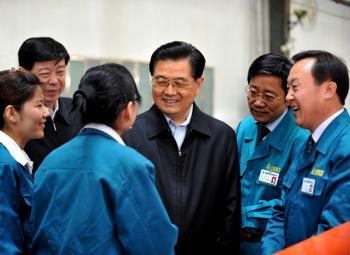 Chinese President Hu Jintao (C) talks to staff members of Jinan Commercial Vehicle Co., Ltd., a subsidiary company of China National Heavy Duty Truck Group Co., Ltd., in Jinan, east China's Shandong Province, on April 21, 2009. Hu Jintao made an inspection tour in Shandong Province on April 21-22. (Xinhua Photo)