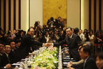 Zheng Lizhong (L), vice-president of the mainland's Association for Relations Across the Taiwan Straits (ARATS), shakes hands with Kao Koong Liann, vice chairman and secretary-general of Taiwan-based Straits Exchange Foundation (SEF), before the preliminary discussion in Nanjing, capital of east China's Jiangsu Province, April 25, 2009. ARATS President Chen Yunlin and SEF Chairman Chiang Pin-kung are scheduled to hold talks on Sunday.(Xinhua/Xing guangli)