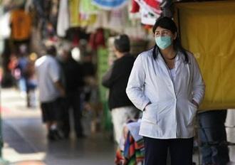 Pharmacy workers wait for customers while wearing surgical masks in Tijuana, Mexico.(AFP/Getty Images/Sandy Huffaker)