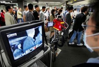 A quarantine officer monitors travelers with a thermographic device at an arrival gate at Narita International Airport in Narita, east of Tokyo, Japan, Sunday, April 26, 2009. (AP Photo/Itsuo Inouye)