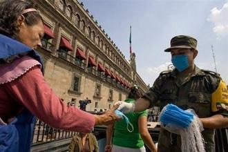 A soldier hands out masks outside the National Palace in Mexico City.  (AFP/Alfredo Estrella)