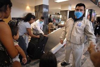 Airport employees wear masks as a preventive measure against a possible swine flu infection in Tijuana, Mexico.(AFP/David Maung)