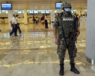 A Mexican soldier wears a surgical mask as he stands guard at Mexico City's international airport Benito Juarez April 27, 2009.REUTERS/Felipe Leon