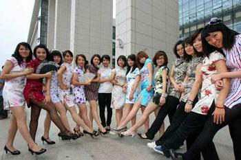 Graduate girls wearing traditional Chinese dress Qipao pose for graduation photos in Guangzhou University on the day of their graduation. [Photo: Guangzhou Daily]