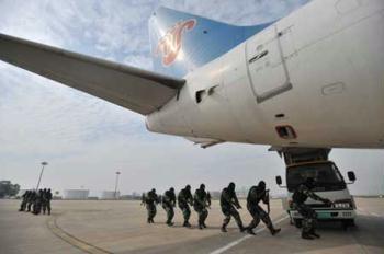 Soldiers sneak up onto the "hijacked" plane in the anti-hijacking exercise held at Tianhe Airport in Wuhan, capital of central China's Hubei Province, April 28, 2009. (Xinhua/Zhou Chao)
