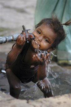 A child drinks water from a roadside water tap during a hot summer day in Bhubaneswar, India, Friday, May 1, 2009. A scorching heat wave has swept through several Indian states leading to at least 18 deaths, the weather department and official said Friday.(AP Photo/Biswaranjan Rout) 