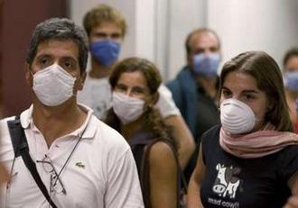 Argentine tourists wear surgical masks inside the airport in Mexico City May 3, 2009. REUTERS/Jorge Dan