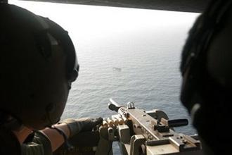 In this photo taken on Monday, May 4, 2009 and released by South Korea's Joint Chiefs of Staff, South Korean snipers on a helicopter aim at a pirate ship about 37 kilometers (23 miles) south of Aden port in Yemen. (AP Photo/ South Korea's Joint Chiefs of Staff, HO)