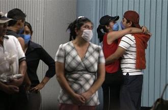 A couple embraces as they wear masks as a precaution against swine flu in the subway in Mexico City, Monday, May 4, 2009.  (AP Photo/Gregory Bull)