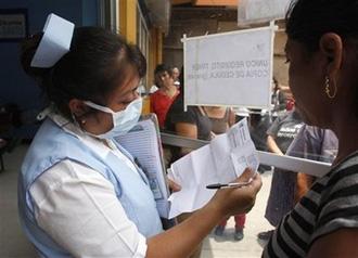 A nurse, wearing a protective mask as a precaution against the swine flu, talks to a patient at a hospital in Guatemala City, Tuesday, May 5, 2009.(AP Photo/Moises Castillo)