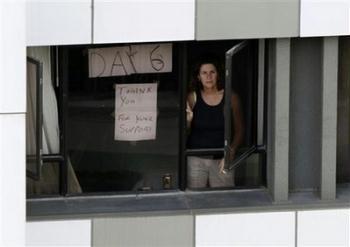 A hotel guest who were under forced quarantine in day 6th, looks through the window of the Metropark Hotel after police sealed off the area in Hong Kong Wednesday, May 6, 2009. A chartered flight departed Hong Kong for Mexico City early Wednesday after picking up Mexicans who were quarantined across China amid swine flu fears. The AeroMexico plane also stopped in Shanghai, Beijing and the southern city Guangzhou.