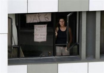 A hotel guest who were under forced quarantine in day 6th, looks through the window of the Metropark Hotel after police sealed off the area in Hong Kong Wednesday, May 6, 2009. A chartered flight departed Hong Kong for Mexico City early Wednesday after picking up Mexicans who were quarantined across China amid swine flu fears. The AeroMexico plane also stopped in Shanghai, Beijing and the southern city Guangzhou.