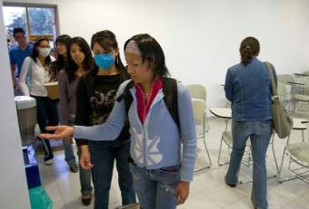 Students spray hand sanitizer before attending classes at the National Autonomous University of Mexico (NAUM) in the Mexico City May 7, 2009. All high schools and universities in Mexico resumed classes on Thursday as the government said the worst of the flu crisis is over.(Xinhua/David De la Paz)