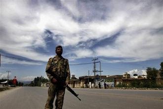 A Pakistani army soldier stands guard on a road leading to Pakistan's troubled valley of Swat where government security forces are fighting with Taliban militants, in Mardan near Peshawar, Pakistan Wednesday, May 6, 2009.(AP Photo/Mohammad Sajjad)