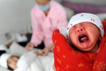 Zhang Xiaoyan's newborn cries at a prefab hospital in Qingchuan, southwest China's Sichuan Province on Sunday, May 10, 2009. New lives never stop their steps to be born in the quake-devastated areas. So far more than 300 newborns have been born at the prefab hospital and these newborns, for those families in the quake-hit areas, are their "sunshine", igniting their hope to start a new life. Pregnant mothers, among whom are mothers who lost their children in the devastated Wenchuan Earthquake on May 12, 2008, are often seen nowadays in the prefabs and newly-built houses. When there are offspring, there is hope and future. The moment of new birth is endowed with significance as the one-year anniversary of the Wenchuan Earthquake approaches. [Photo: Xinhua/Li Ziheng/Cai Yang]