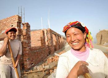 Photo taken on April 19, 2009, shows two villagers in Maigongshan Village, Tielou Township, Wenxian County, Gansu Province, smile while rebuilding their new houses. (Xinhua Photo)