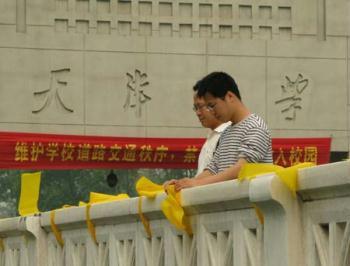 Voluteers fasten yellow ribbons on handrails outside Tianjin University in north China's Tianjin, May 12, 2009. Volunteers tied thousands of yellow ribbons on buses, buildings and trees as a way to commemorate the victims of the May 12, 2008 Wenchuan earthquake.(Xinhua Photo)